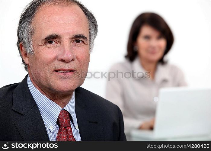 Middle-aged business couple with laptop