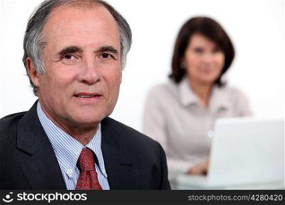 Middle-aged business couple with laptop