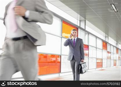Middle aged businessman on call while walking in railroad station