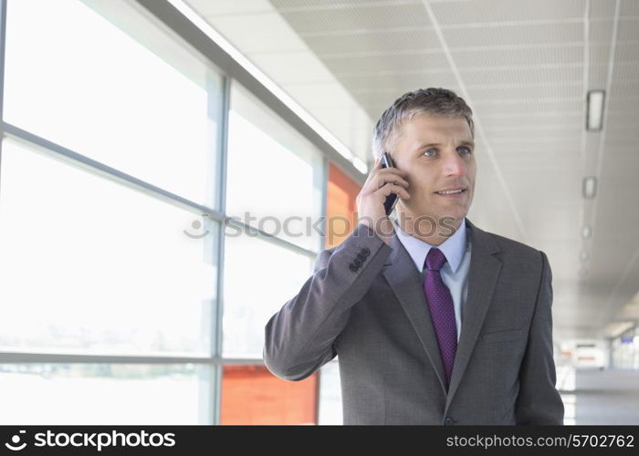 Middle aged businessman using mobile phone at train station