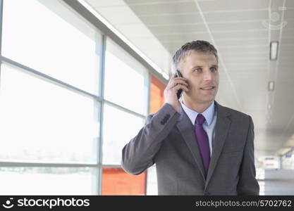 Middle aged businessman using mobile phone at train station