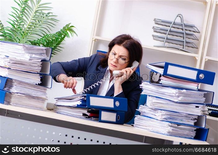 Middle-aged businesswoman unhappy with excessive work 