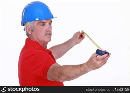Middle-aged carpenter holding tape measure