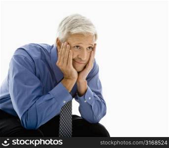 Middle aged Caucasian man with head resting in hands looking bored.