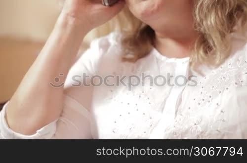 Middle-aged caucasian woman speaking on the mobile phone emotionally