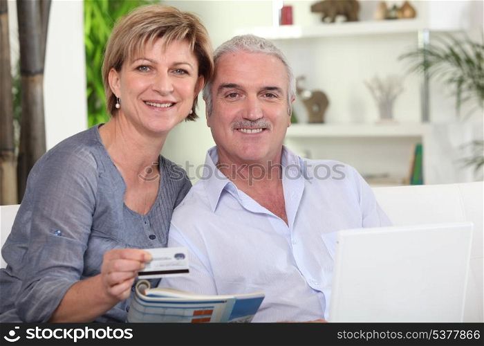 middle-aged couple all smiles with computer sharing moment