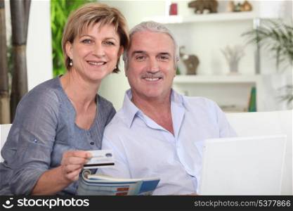 middle-aged couple all smiles with computer sharing moment