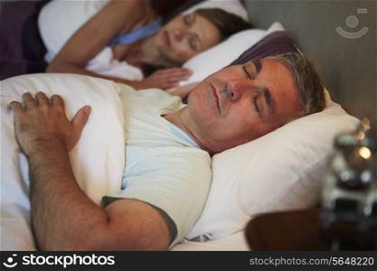 Middle Aged Couple Asleep In Bed Together