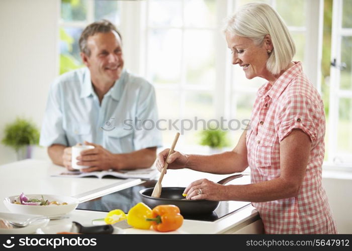 Middle Aged Couple Cooking Meal In Kitchen Together