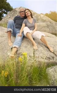 Middle aged couple, cuddling on rocks