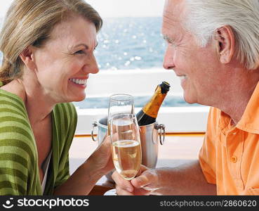 Middle-aged couple drinking champagne on yacht side view close-up