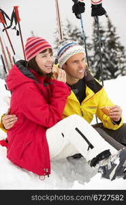 Middle Aged Couple Eating Sandwich On Ski Holiday In Mountains