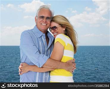 Middle-aged couple embracing against sea portrait