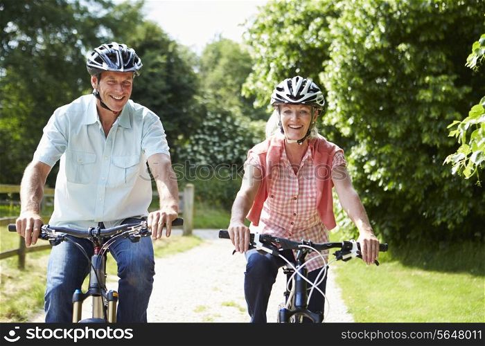 Middle Aged Couple Enjoying Country Cycle Ride Together