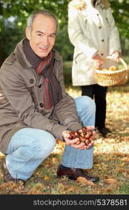 Middle-aged couple gathering chestnuts