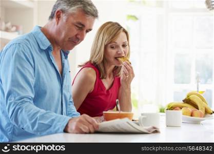 Middle Aged Couple Having Breakfast In Kitchen Together