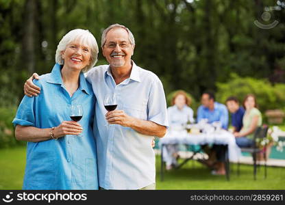 Middle-aged couple in back yard with glasses of wine portrait