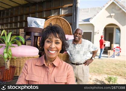 Middle-aged couple in front of lorry with furniture