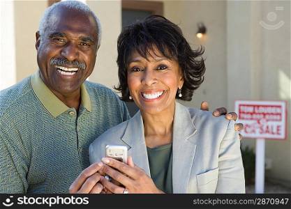 Middle-aged couple in front of new home