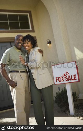 Middle-aged couple in front of new home