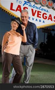 Middle-aged couple in front of Welcome to Las Vegas sign, portrait