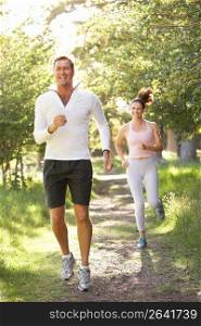 Middle Aged Couple Jogging In Park