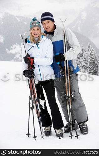 Middle Aged Couple On Ski Holiday In Mountains