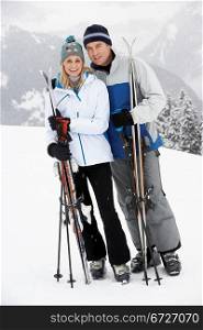 Middle Aged Couple On Ski Holiday In Mountains