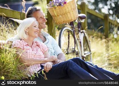 Middle Aged Couple Relaxing On Country Cycle Ride
