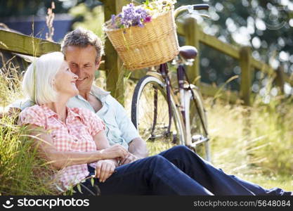 Middle Aged Couple Relaxing On Country Cycle Ride