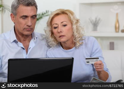 Middle aged couple shopping online.