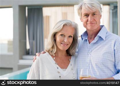 Middle aged couple standing outside house