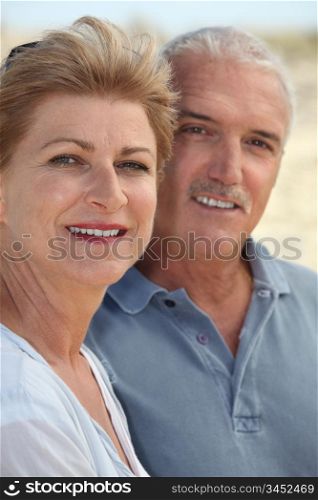 Middle-aged couple stood on beach