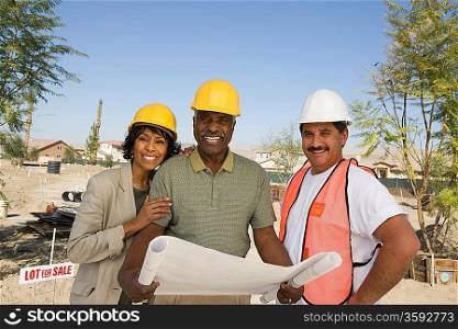 Middle-aged couple watching blueprints with surveyor, portrait