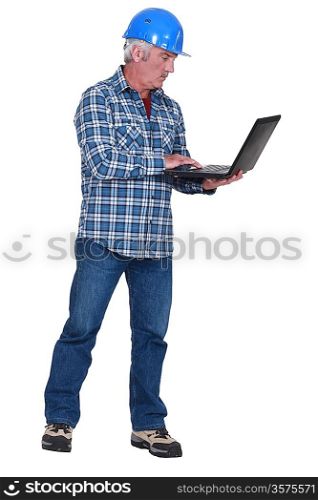 middle aged craftsman standing with laptop