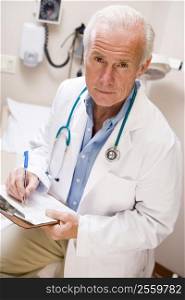 Middle Aged Doctor Writing On His Clipboard
