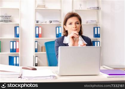 Middle-aged female employee sitting at the office  