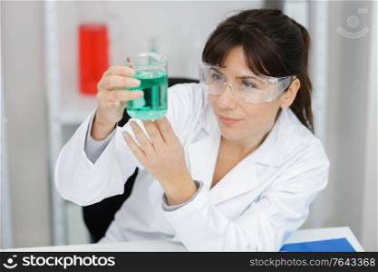 middle-aged female scientist looks at plastic tubes