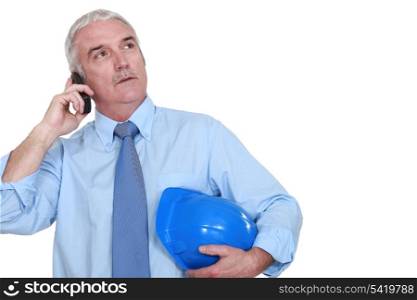 middle-aged foreman making a call hard hat in hand