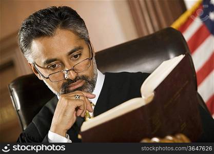 Middle-aged judge reading in a courtroom