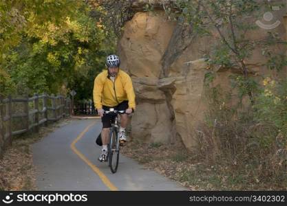 middle aged male riding a bike or commuting on biking trail, Poudre River Corridor Trail near Greeley, Colorado, fall scenery