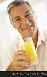 Middle Aged Man Drinking A Glass Of Orange Juice