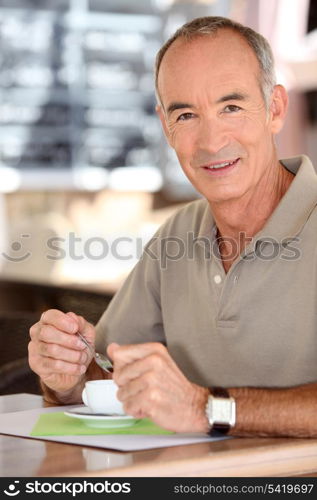 Middle-aged man drinking coffee on terrace