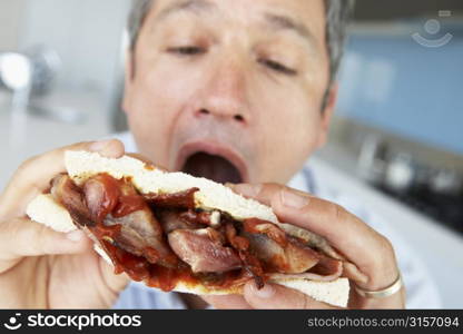 Middle Aged Man Eating A Bacon Sandwich