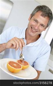 Middle Aged Man Eating Fresh Grapefruit