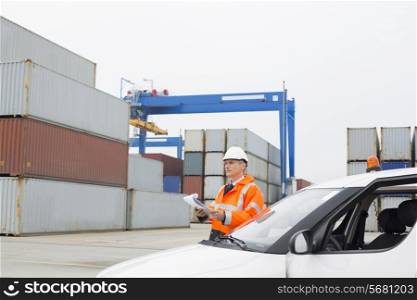 Middle-aged man examining cargo in shipping yard