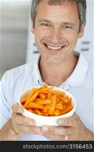 Middle Aged Man Holding A Bowl Of Carrots