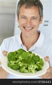 Middle Aged Man Holding A Plate Of Broccoli