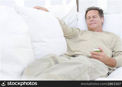 Middle-aged man listening to music on sofa