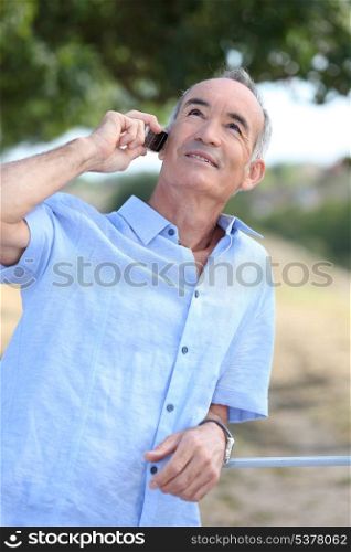 Middle-aged man outdoors with mobile telephone